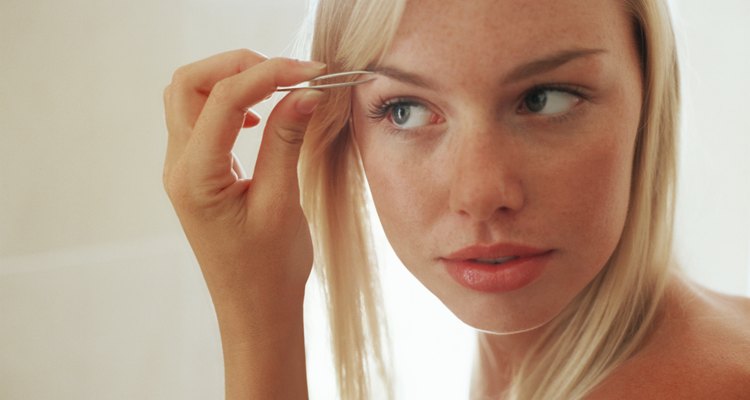 Woman plucking her eyebrow