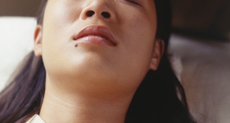 Young woman having eyebrows waxed in beauty parlour, elevated view, close-up