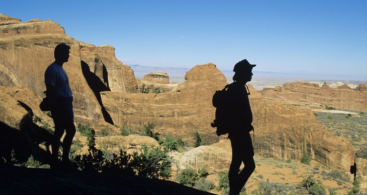 Los caminantes se detienen a ver el paisaje en el Arches National Park.