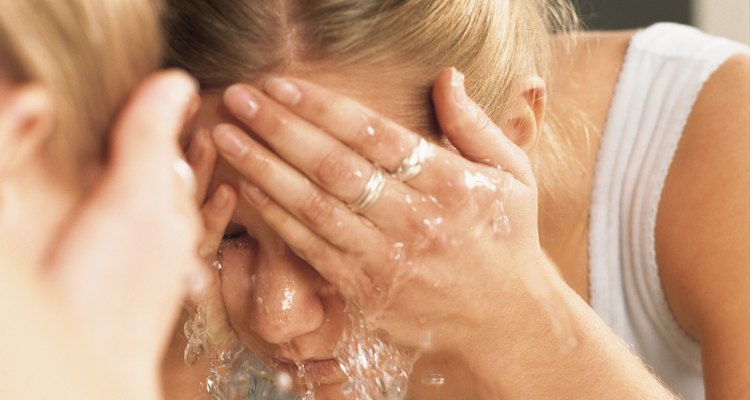 beautiful woman splashing face with water with reflection