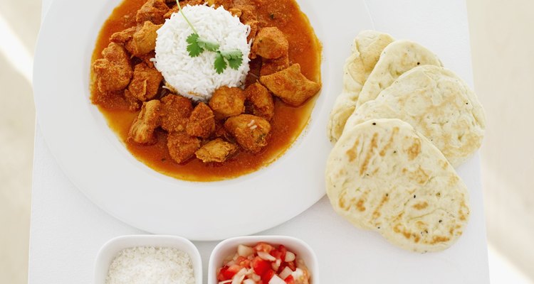 Elevated view of white rice and curry served with salad and bread