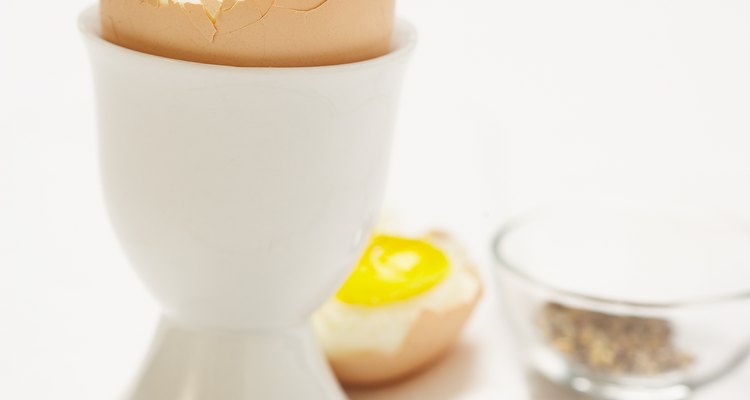 Hard boiled egg served in cup with pepper