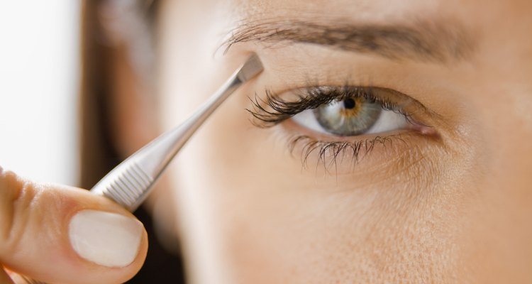 Woman plucking her eyebrows