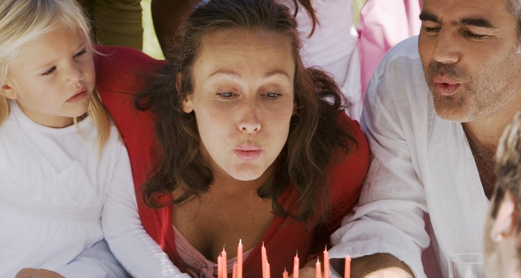 Woman blowing out candles at party