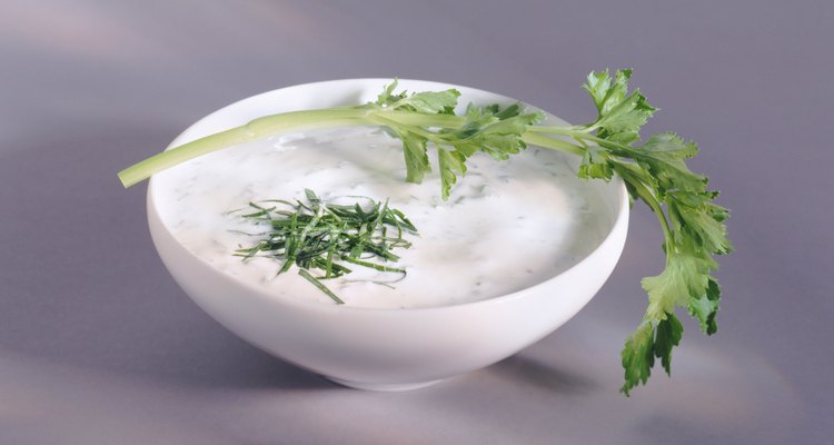 Yoghurt in bowl with leaf, close-up