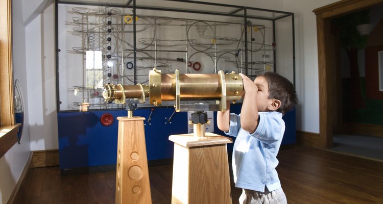 Un niño observa a través de un telescopio en un museo.