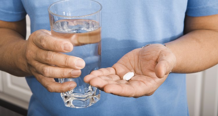 Man Holding Pill and Glass of Water