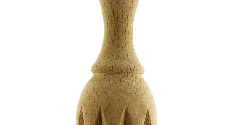 Un simple escariador de madera remueve sólo una parte del jugo de la pulpa de los cítricos.