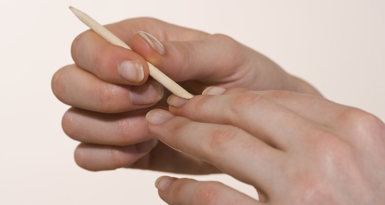 Woman using cuticle pusher