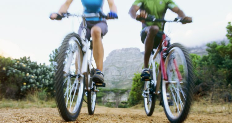 Low angle view of a young man and a young woman mountain biking