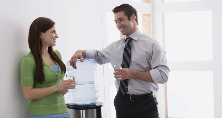 Co-workers smiling by water cooler