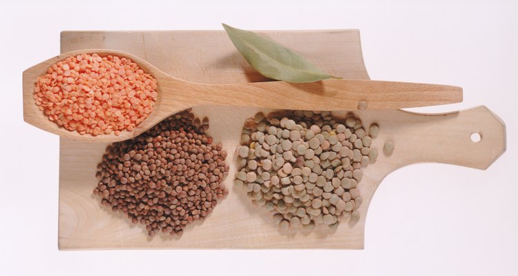 Bay leaf, chickpea, green pea, lentil and spoon on chopping board, close-up