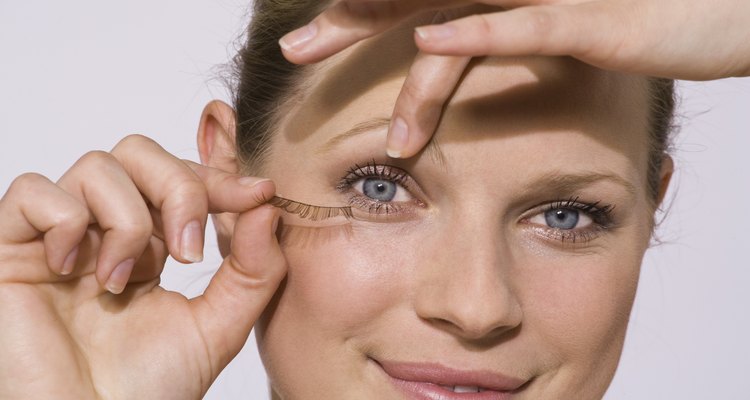 Woman applying false eyelashes