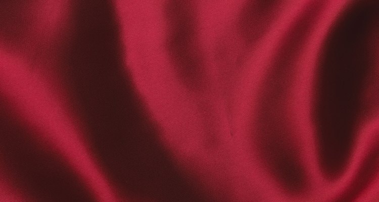 Super Glue spilt on satin fabric leaves a dark, hardened stain.