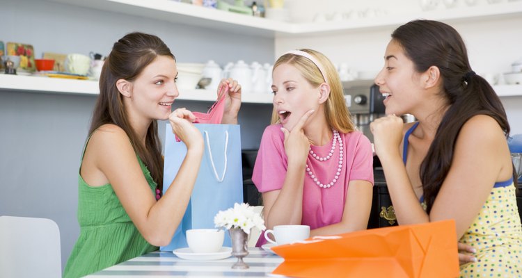 Three young woman sitting at a table taking a break from shopping