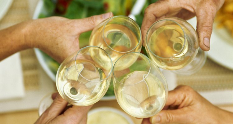 Elevated view of four glasses of white wine held together