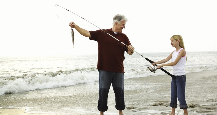 Father and daughter fishing on beach