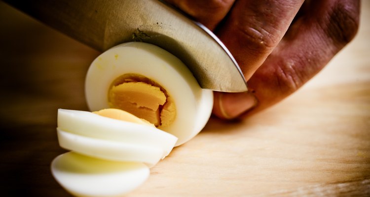 Close-up of cook slicing hard-boiled egg