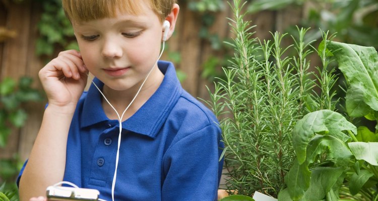 Boy listening to music player in the garden