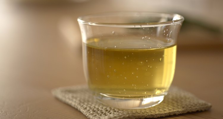 Glass of green tea on coaster, close-up