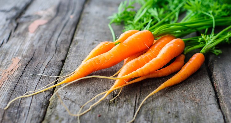 Bunch of fresh washed carrot on the old wooden background