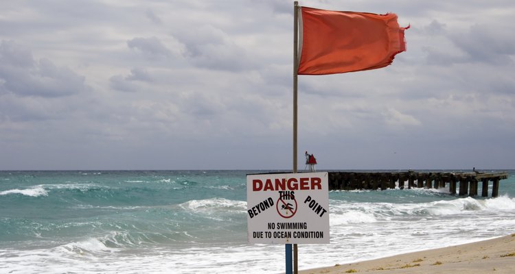 Una bandera de advertencia roja cerca del agua.