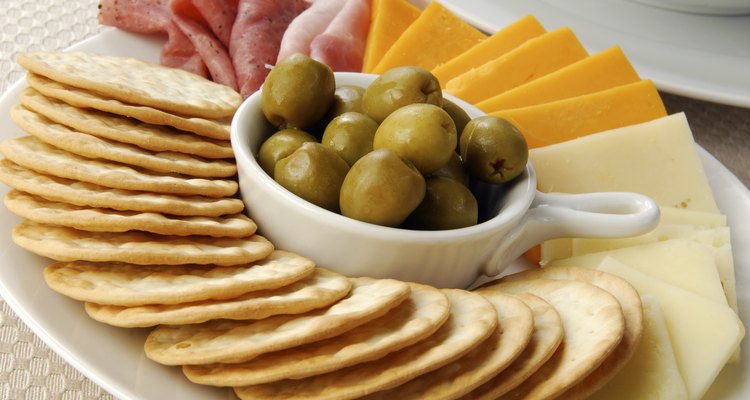 Bolachas com fatias de presunto, cheddar e queijo suíço com azeitonas