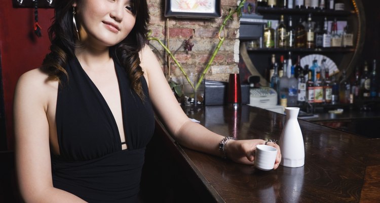 Smiling woman with sake at bar