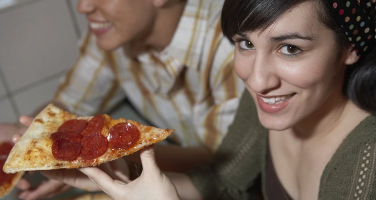 Teenage couple eating pizza