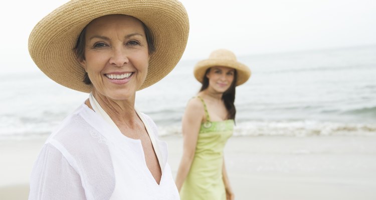 Mother and daughter in sunhats on beach
