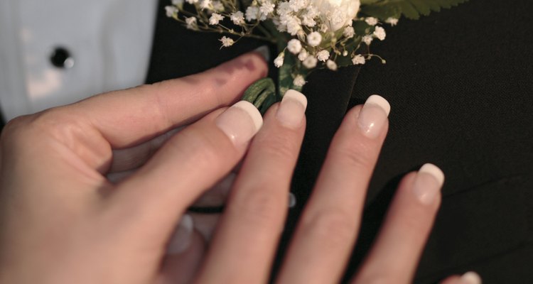 Woman putting boutonniere in man's buttonhole