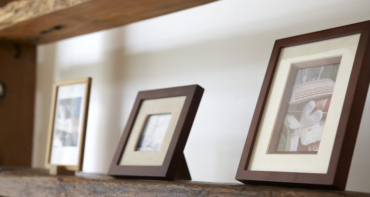 Framed photos on wooden shelf, close-up