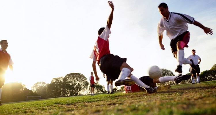 Soccer players tackling for ball, ground view