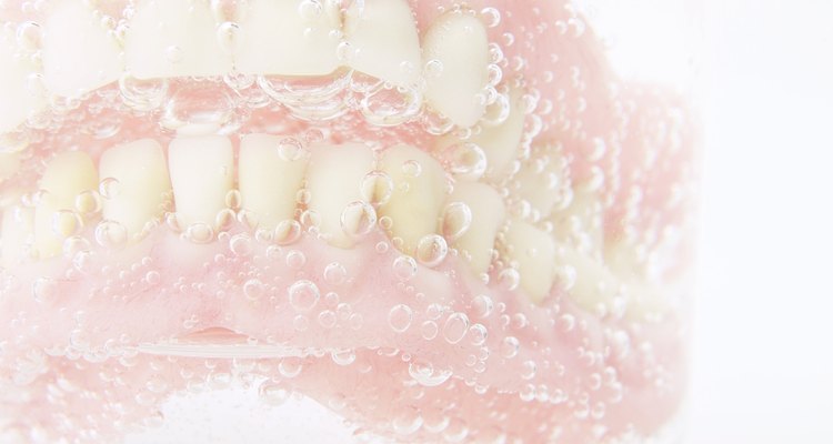 Soaking dentures in water is OK, soaking them in straight bleach is not.
