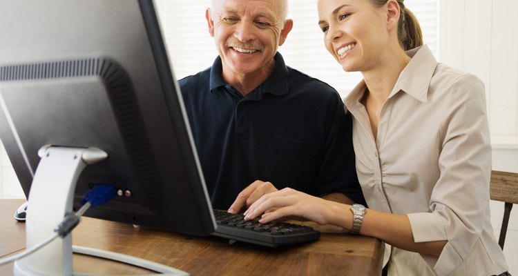 Woman helping man with computer