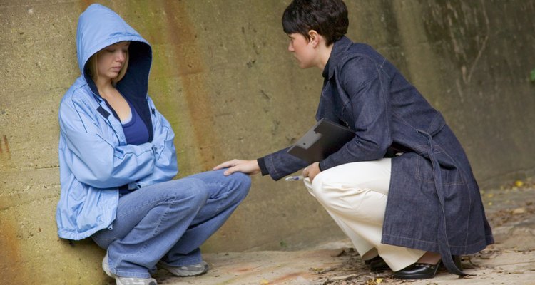 Social worker talking with frightened homeless girl