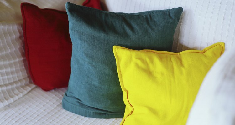 Transforma tu cama en un sofá con algunos cojines.