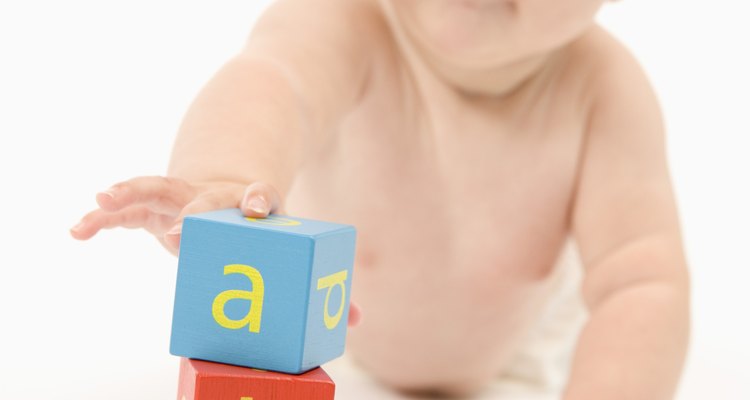 Jugar con juguetes estimula a tu bebé a agarrar objetos para su desarrollo físico.