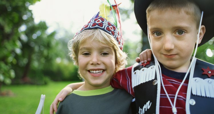 Portrait of two boys pretending to be a cowboy and an Indian