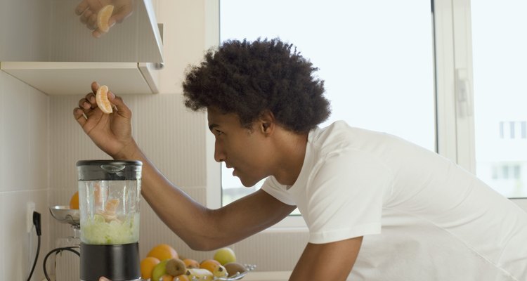 Homem colocando fruta no liquidificador