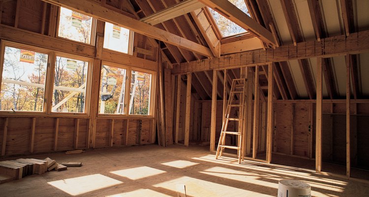 Los trabajadores de la construcción utilizan vigas y placas de madera para construir una casa.
