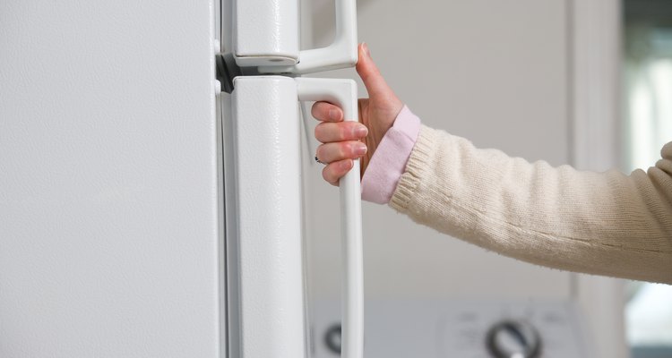 Hand of woman opening refrigerator door