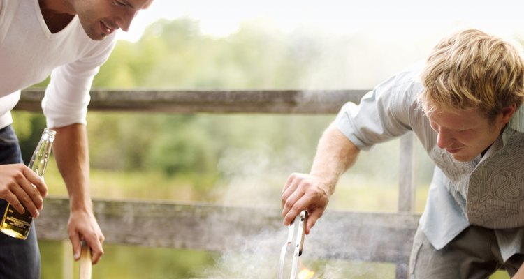 Two men grilling chicken