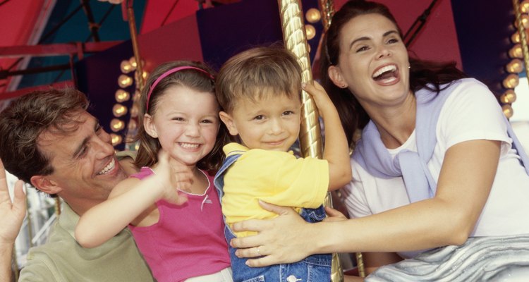 Young couple sitting on a carousel with their son and daughter