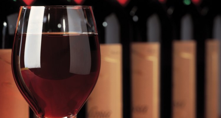 close-up of a glass of wine in front of an array of bottles