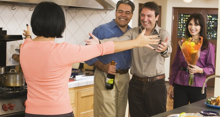 Middle-aged friends greeting in kitchen