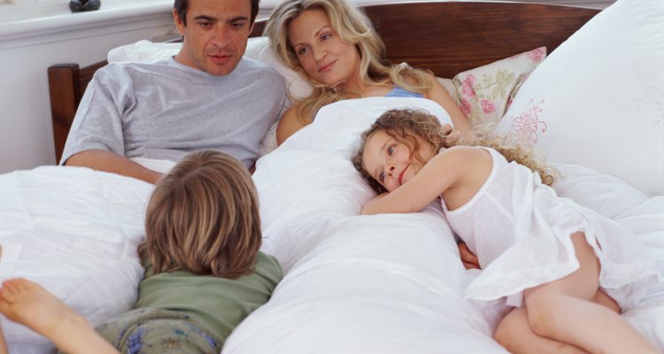 Parents lying in bed with son and daughter (4-6)