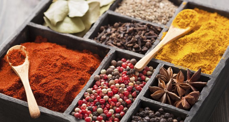 spices box: pink black pepper, paprika powder, curry, bay