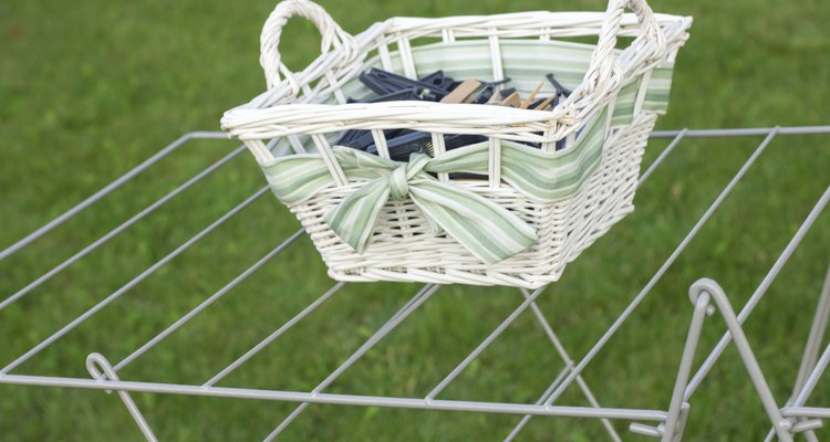Wicker basket of clothes pegs on a wire drying stand.