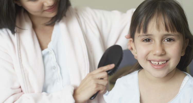 Mother combing her daughter's hair